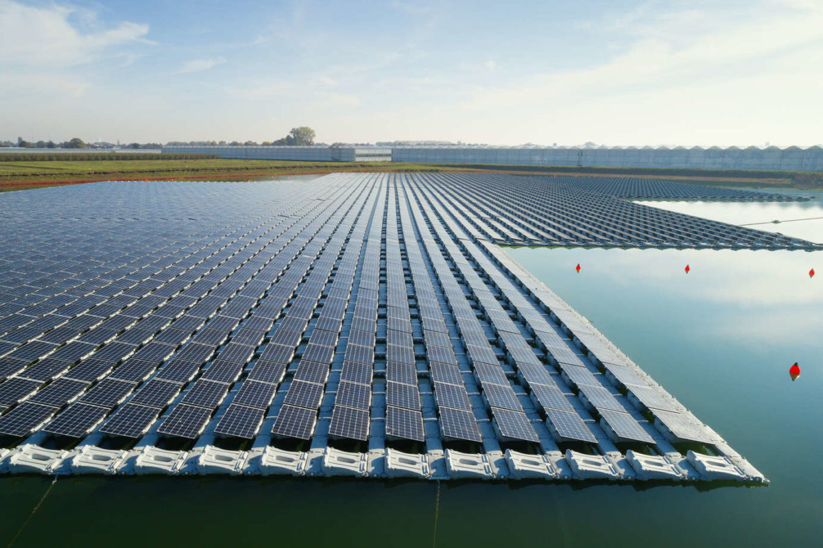 Floating solar panels installed on water supply of neighbouring greenhouses, elevated view, Netherlands