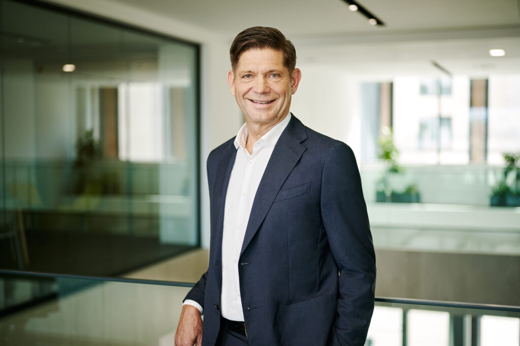 Bernhard Suchland, stands in an office.
