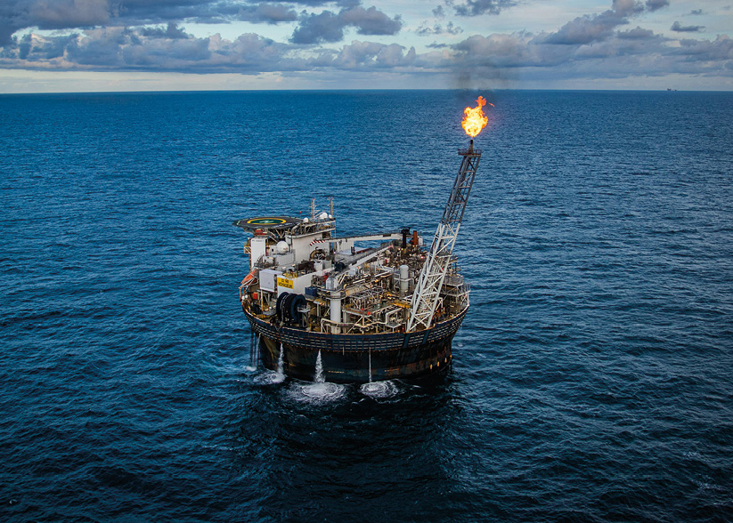 Image shows an offshore oil platform with flare burning.