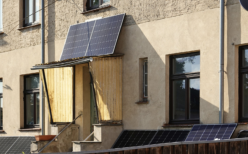 Solar panels precariously placed above the doorway to a house.