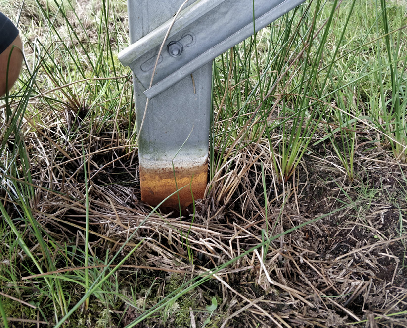 A PV installation foundation pile, with rust spreading close to where it meets the ground.