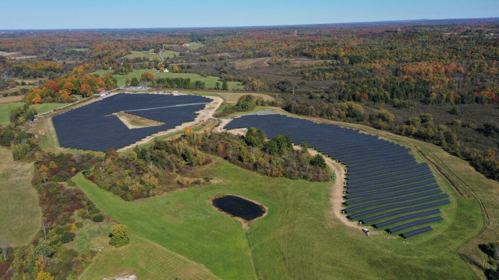 Aerial view of a PV system surrounded by forested land.