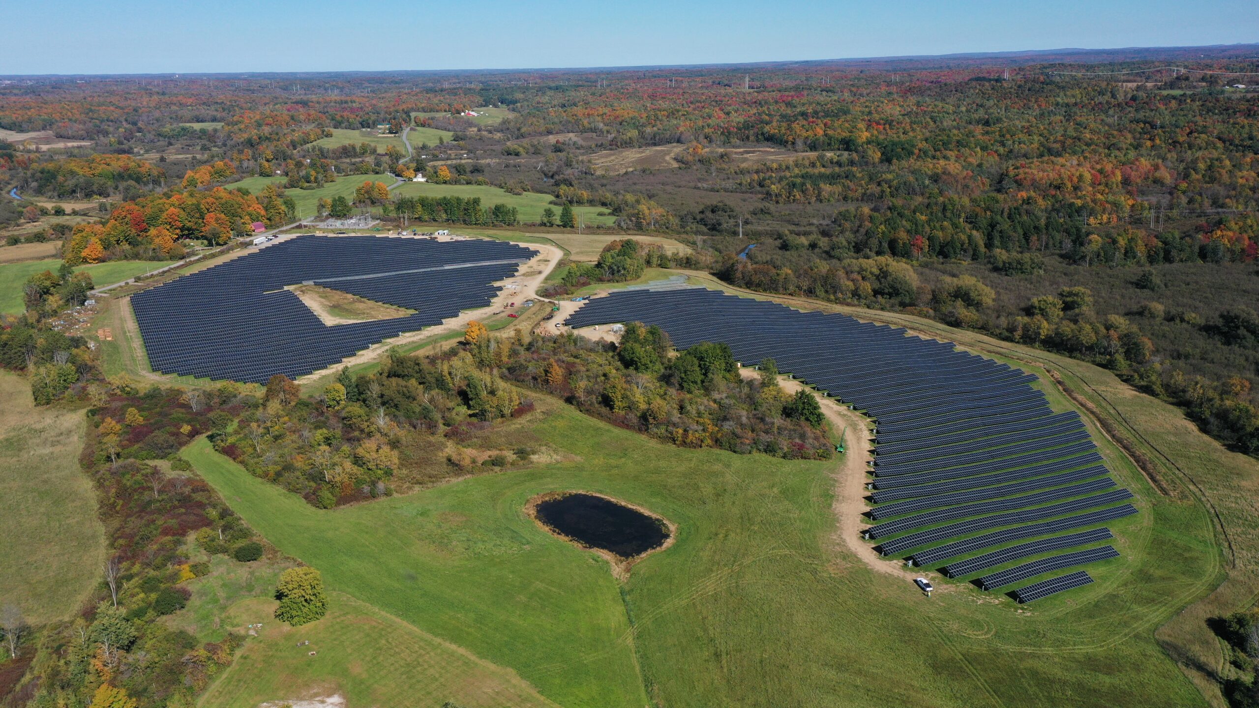 Aerial view of a PV system surrounded by forested land.