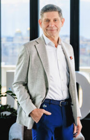 Bernhard Suchland in an office, with a city background.