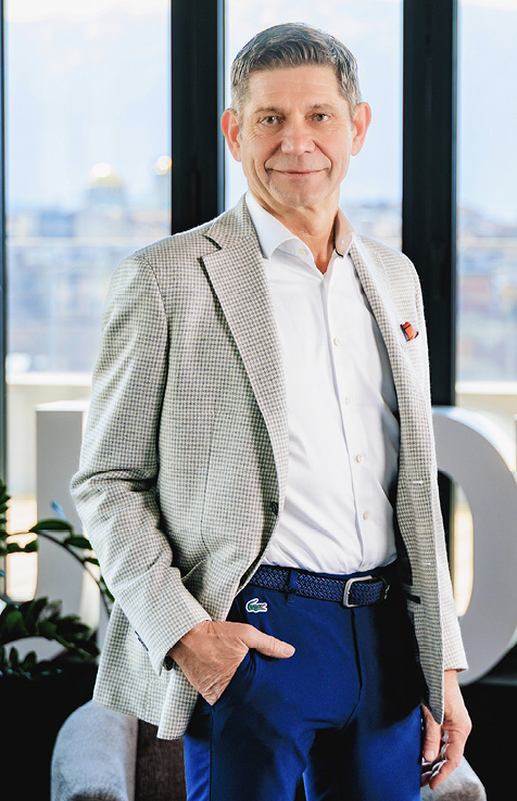 Bernhard Suchland in an office, with a city background.